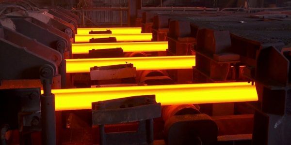 Hot steel billets moving through an industrial production line